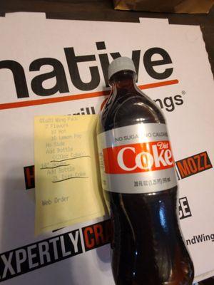 20 oz diet coke next to the receipt that says 2 L diet coke on it.