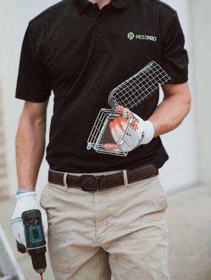 A Pest Pro technician holding wildlife trapping materials.