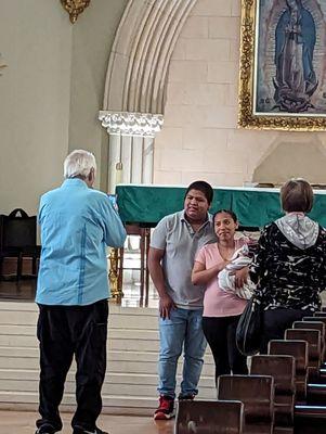 These people are taking their newborn boys picture in the church