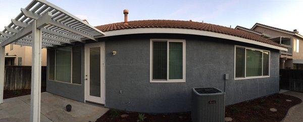 Backyard, with painted patio and new windows in middle on on the right.