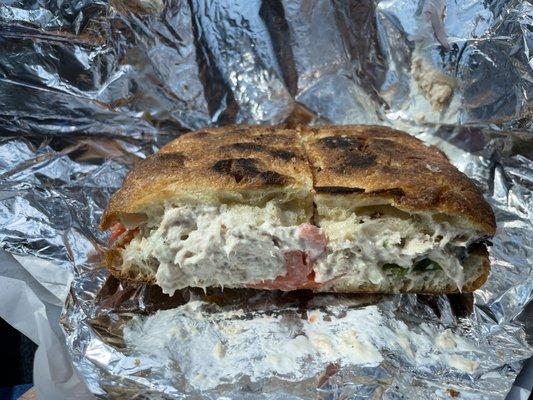 A beautiful Tuna Melt on focaccia with American Cheese, Lettuce, Onion, Tomato