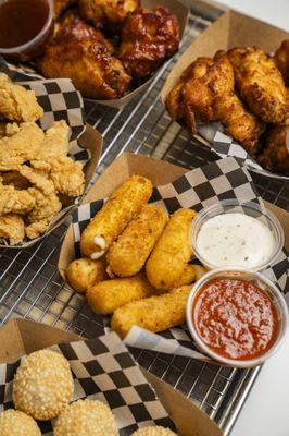 Mozzarella cheese sticks, chicken wings, sesame balls, and chicken bites