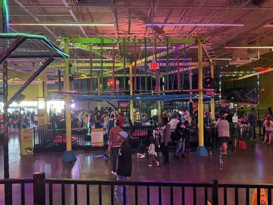 This shows the air flyer course and ropes course with the bumper cars underneath and climbing gym behind.