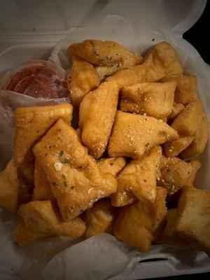 Pizza Puffs: Bite-Sized pizza dough, deep-fried & tossed in signature spice blend, served w/ pizza sauce.