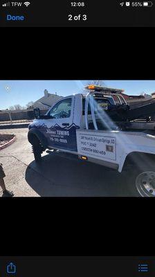 Company truck towing wife's car.