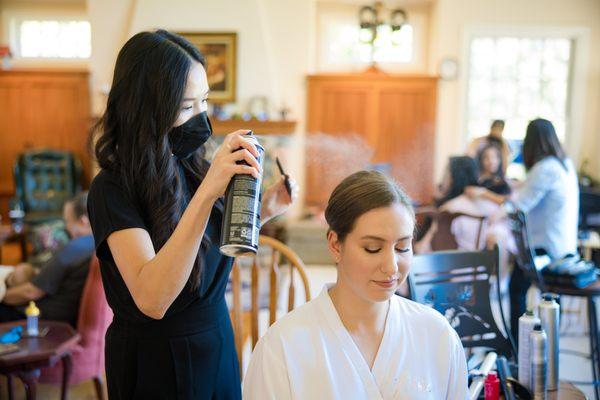 Finishing with hairspray. Photo by Toanven Photography