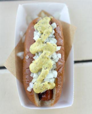 Grilled hot dog with onions and Dijon mustard