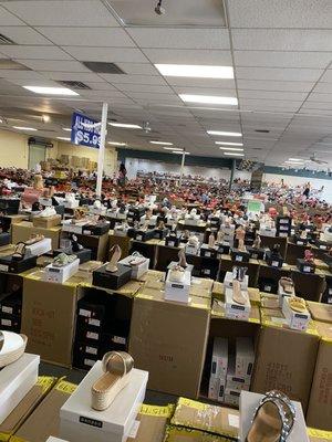 Rows of shoes that you can only try on in front (announcements constantly made)