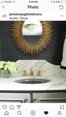 Custom urban chic bathroom with Carrera marble surface and backsplash and antique iron and gold plated mid century sunburst mirror