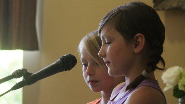 Sisters sharing a song at their first recital.