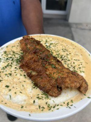 Our Krispy Fried Catfish with a Cajun Cream sauce on a bed of Fluffy grits