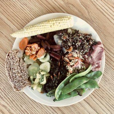 Quinoa tabouli, cucumber salad, red Swiss chard, snow peas, cole slaw, kale salad, hummus, sautéed carrots, mini corn, whole grain sourdough