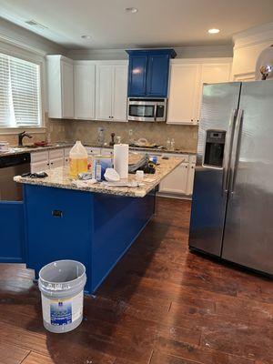 We turned old, out dated wood stain cabinets into nice white cabinets with a blue island for contrast! Most people are over brown cabinets!