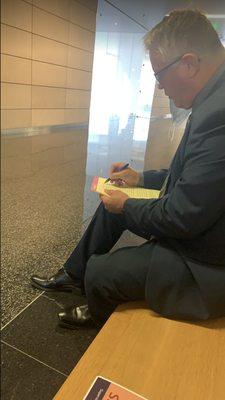 Casey writing up to the negotiated deal outside of the courtroom.