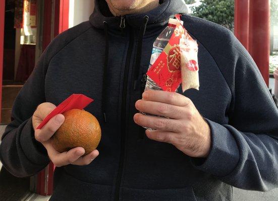 We paid 3 dollars for a bundle of lucky charms: the rice, the water and a red envelop. They also gave us some oranges for good luck.