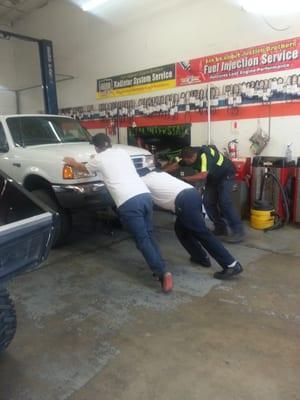 Gio does more than work on cars he helps the tow truck driver make delivery on an after hours Friday evening.