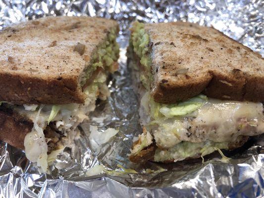 Grilled Tilapia sandwich w/lettuce, tomato, cheese, Mayo, Chile and guacamole on whole grain bread.