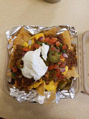 Nachos with ground beef,  salsa, jalepeños, and sour cream.