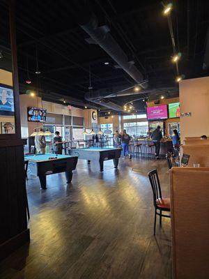 The bar with pool tables in the back and lots of open space.