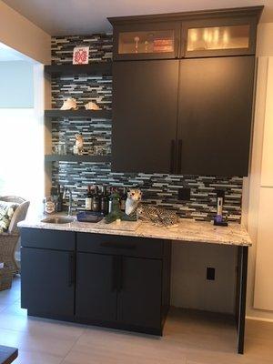 Bar area in Slab door style in Black painted finish with glass tile backsplash