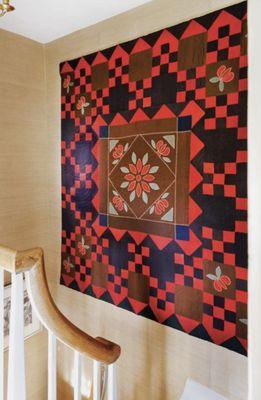 Antique quilt hung in a stairwell.