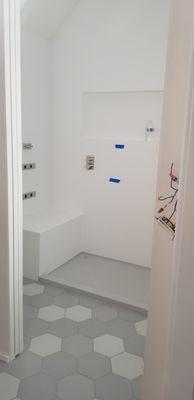 Custom Corian shower pan connected to the walls with silicone