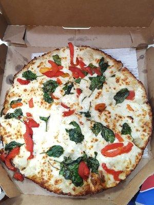 Pan pizza with garlic parmesan white sauce topped with spinach and red bell peppers. It looks yummy.