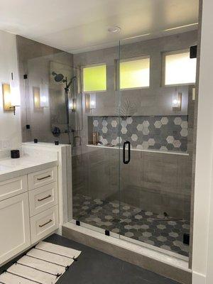 Crystal clear (starphire) 1/2" thick glass with matte black hardware in this custom 2-panel frameless shower glass enclosure.