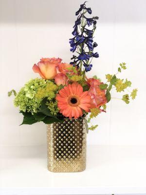 Fun and colorful arrangement in a gold vase