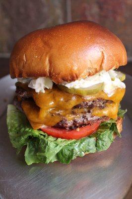 New burger on the menu, double angus beef patties with sharp cheddar, lettuce, tomato, onion, and sherry mayo on a brioche bun.