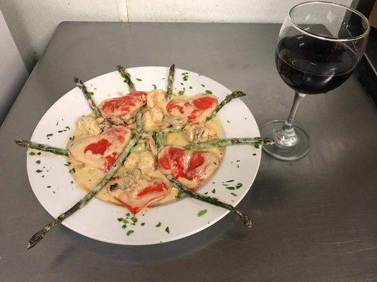 Hearth shaped ravioli with shrimp and asparagus topped with lobster cream sauce .