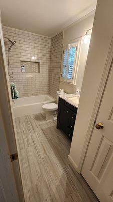 Tiled shower, new tub, flooring and vanity.