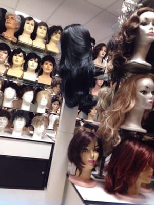 some toppers for people with thinning hair, a full black wig and some men's wig