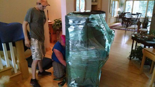 Shrink wrapping and padding the piano for final transport to Minnesota.