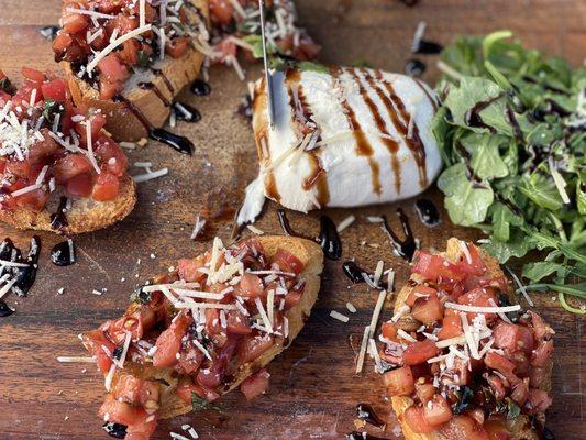 Bruschetta with fresh burrata and arugula salad.