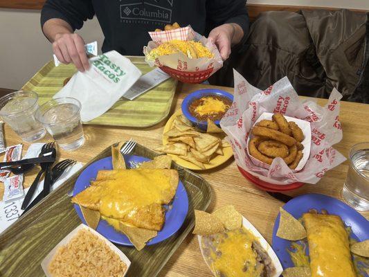 Tacos, enchiladas  , onion rings, taters, rice and beans, chili