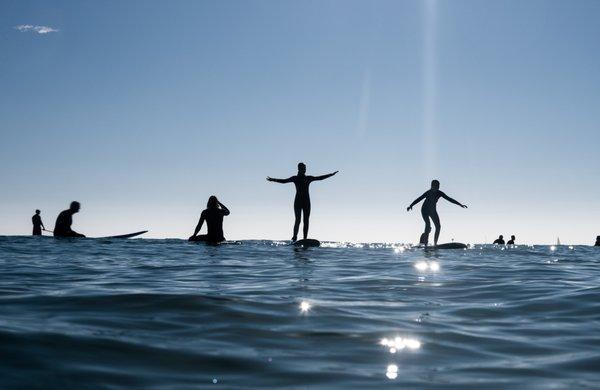 Surf Academy owner Alek Rockrise looking for waves while father Chris Hart and his twin daughters, Phoebe and Penny, pass the time.