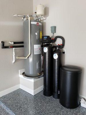 Can't have a water treatment system in front of your car...so the plumbing is around the water heater to a better location.