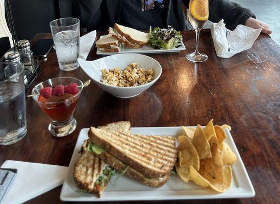 Goat Grilled Cheese Sandwich with chips, Prosciutto, Pecorino Toscano and Arugula with greens. Sparktini, Sunset Sparkler and Carmel Corn