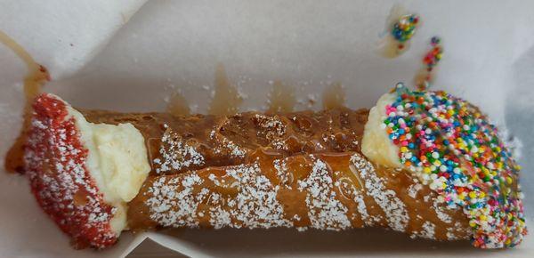 Traditional cannoli with mascarpone, rainbow sprinkles, and caramel drizzle