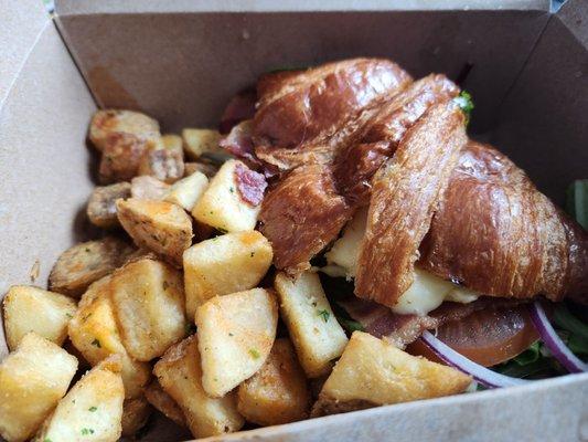 Breakfast sandwich with bacon and fried potatoes