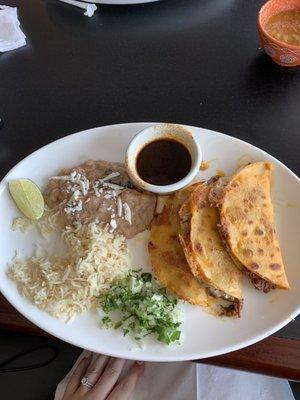 Birria Tacos - brisket tacos served with consume, rice and beans. AMAZING