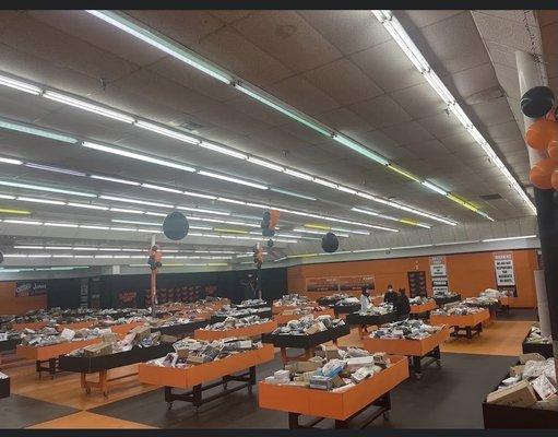 Inside store, tables full of boxes and smaller items.