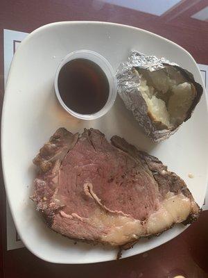 Prime rib with au jus and baked potato.