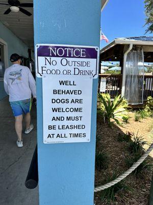 "Well behaved dogs welcome" sign at entrance