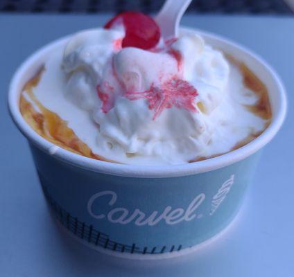 Vanilla soft serve with caramel sauce, whipped cream, and a cherry