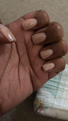 Nude dip powder with glitter top coat on natural nails.