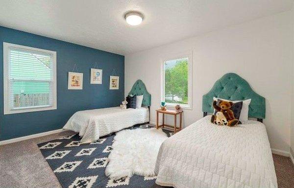 Staged kids double bedroom in white and grey with turquoise headboards.