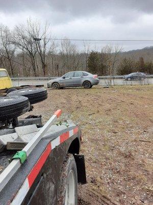 Recovering Ford Focus that had slid down a hill against a fence.