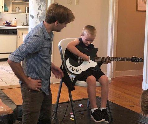 Mr. Blunt at the 2018 Open House showing the kids the basics of the electric bass and guitar